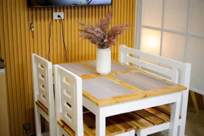 a white table with two chairs and a vase on it at Venice Grand Canal View Condo in Manila
