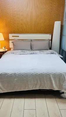 a bedroom with a large bed with a wooden wall at Venice Grand Canal View Condo in Manila