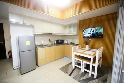 a kitchen with a refrigerator and a table in it at Venice Grand Canal View Condo in Manila