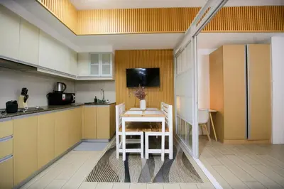 a kitchen with a table and a tv on the wall at Venice Grand Canal View Condo in Manila