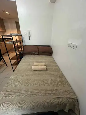 a bed in a room with a blanket on it at Cozy 2 Beds Near Mall of Asia in Manila