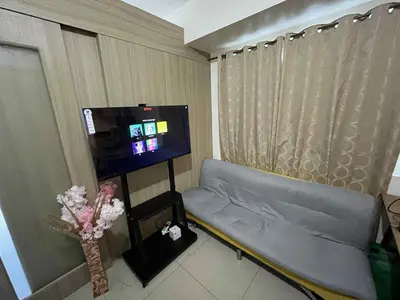 a room with a couch and a flat screen tv at Cozy 2 Beds Near Mall of Asia in Manila