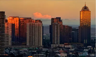 a city skyline with tall skyscrapers at sunset at The Gramercy Residences in Manila