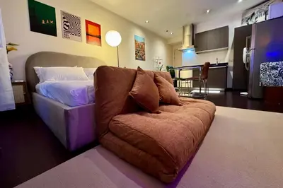 a bedroom with a couch in front of a bed at The Gramercy Residences in Manila