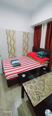 a bedroom with a bed with a red and white comforter at Alabang homely in Manila
