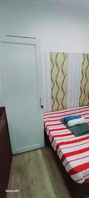 a bedroom with a bed with a white door at Alabang homely in Manila