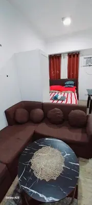a living room with a brown couch and a table at Alabang homely in Manila