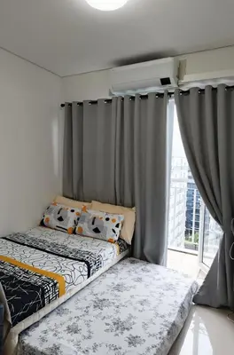 a bedroom with two beds and a window at Condo Staycation Shell Residence in Manila