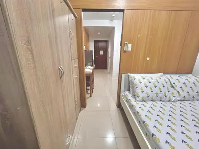 a bedroom with a bed and a hallway with a desk at Condo Staycation Shell Residence in Manila