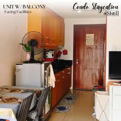 a kitchen with a refrigerator and a fan in it at Condo Staycation Shell Residence in Manila