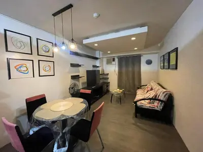 a living room with a table and a couch at Studio Condominium by Koteniko in Manila
