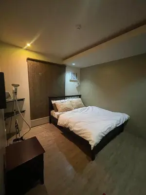 a bedroom with a large bed with white sheets at Studio Condominium by Koteniko in Manila