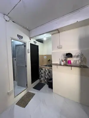 a kitchen with a door open to a kitchen with a counter at Studio Condominium by Koteniko in Manila
