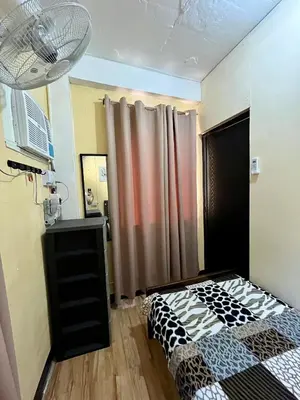 a bedroom with a bed and a curtain at Studio Condominium by Koteniko in Manila