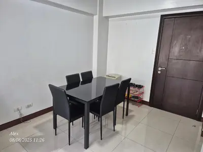 a black dining room table with black chairs and a door at 1BR Condo at NAIA and Newport Casino Area in Manila