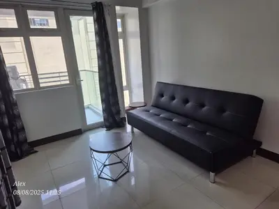 a black couch in a living room with a table at 1BR Condo at NAIA and Newport Casino Area in Manila