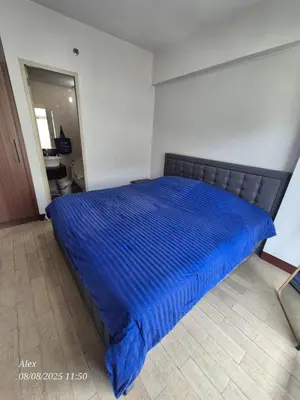 a bed in a room with a blue blanket on it at 1BR Condo at NAIA and Newport Casino Area in Manila