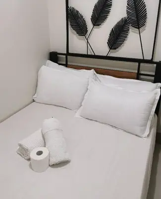 a white bed with two rolls of toilet paper on it at Mall of Asia condotel shore 3 residence Aldo Staycation in Manila