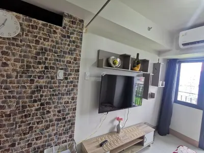 a living room with a tv and a brick wall at Mall of Asia condotel shore 3 residence Aldo Staycation in Manila