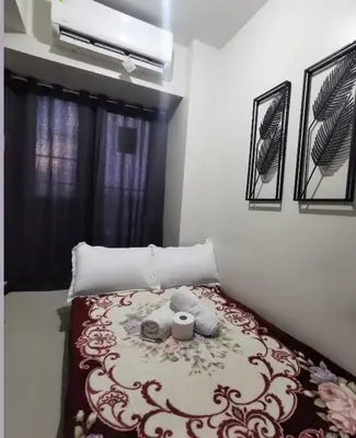 a bed with two towels on it in a bedroom at Mall of Asia condotel shore 3 residence Aldo Staycation in Manila