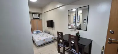 a room with a table and a bed and a mirror at Affordable Rooms by Rqui Near Airports in Manila