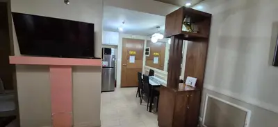 a living room with a large flat screen tv on a wall at Affordable Rooms by Rqui Near Airports in Manila