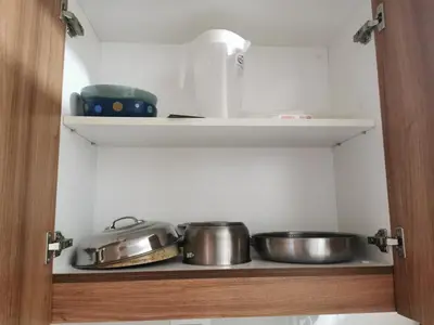 a kitchen with two pots and pans on a shelf at Mall of Asia condotel shore 3 in Manila