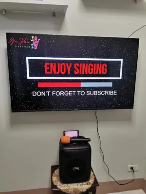a sign hanging on a wall with a sign that says enjoy singing dont forget to at Mall of Asia condotel shore 3 in Manila
