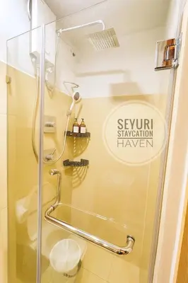 a shower with a glass door in a bathroom at Seyuri Staycation Haven in Manila