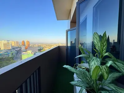 a plant on a balcony with a view of a city at The Cube in Cubao in Quezon City