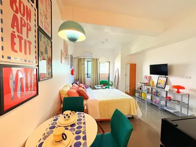 a bedroom with a bed and a table and chairs at The Cube in Cubao in Quezon City