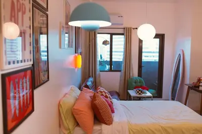 a bedroom with a bed with colorful pillows on it at The Cube in Cubao in Quezon City