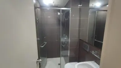 a bathroom with a shower with a toilet and a sink at Aveline Suites Riverline in Manila