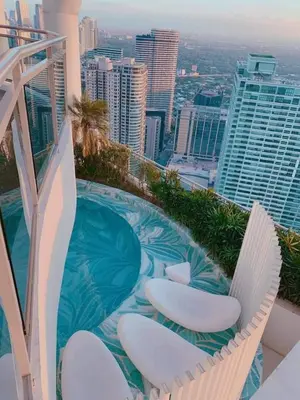 a balcony with chairs and a swimming pool on a building at Aveline Suites Riverline in Manila