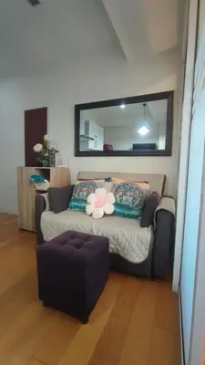 a living room with a couch and a mirror at Aveline Suites Riverline in Manila