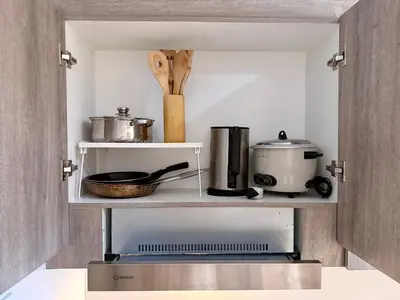 a kitchen with a shelf with various kitchen items on it at Prime Location condo near MRT, SM Megamall, BGC! in Manila