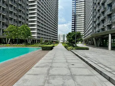 an empty sidewalk in a city with tall buildings at Prime Location condo near MRT, SM Megamall, BGC! in Manila