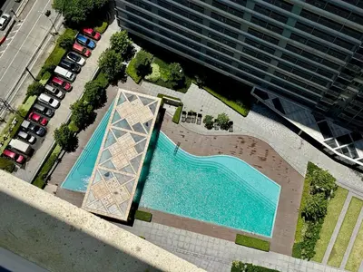an overhead view of a swimming pool in front of a building at Prime Location condo near MRT, SM Megamall, BGC! in Manila