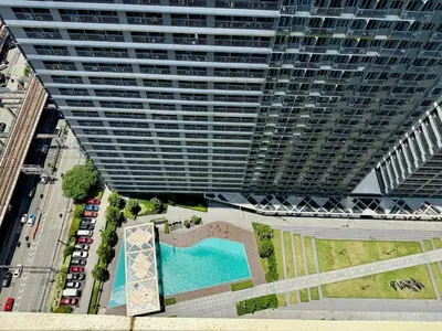 an overhead view of a large building with a pool at Prime Location condo near MRT, SM Megamall, BGC! in Manila