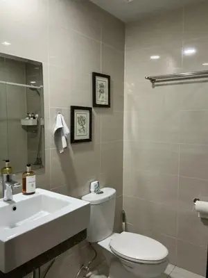 a bathroom with a white toilet and a sink at ONE UPTOWN RESIDENCE BGC 2-bed 1BR in Manila
