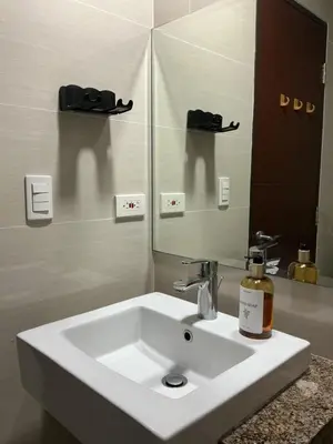 a bathroom sink with a bottle of soap on it at ONE UPTOWN RESIDENCE BGC 2-bed 1BR in Manila