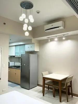 a kitchen with a table and a refrigerator at ONE UPTOWN RESIDENCE BGC 2-bed 1BR in Manila