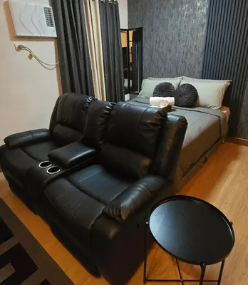 a leather couch and a chair in a living room at SW Staycation Liam Suite SMDC Hope Residences Beside SM City in Trece Martires