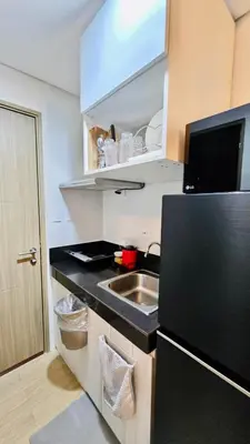 a small kitchen with a sink and a refrigerator at SW Staycation Liam Suite SMDC Hope Residences Beside SM City in Trece Martires