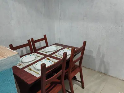 a table with two chairs and a table with plates on it at Harong ni Lynda in Ibaba