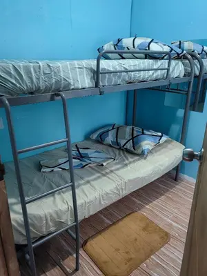 two bunk beds in a room with a blue wall at Harong ni Lynda in Ibaba