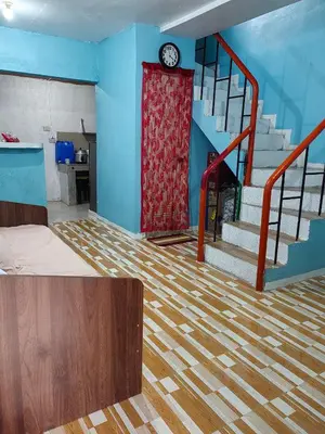 a room with a staircase with a clock on the wall at Harong ni Lynda in Ibaba