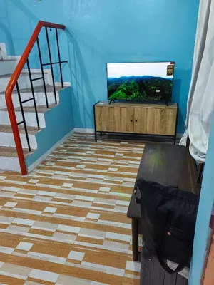 a living room with a tv and a staircase at Harong ni Lynda in Ibaba