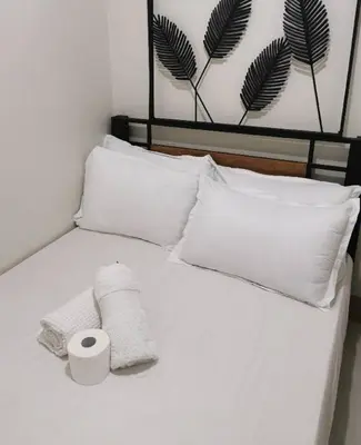 a white bed with two towels and two pillows at Mall of Asia shore 3 tower 2 residence in Manila