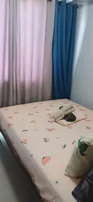 a bed in a room with a curtain and a bed with avertisement at Cozy home in Manila